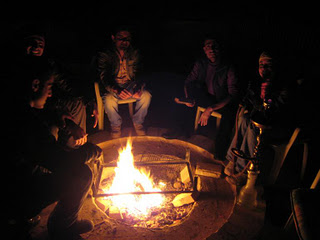 men-seated-around-campfire